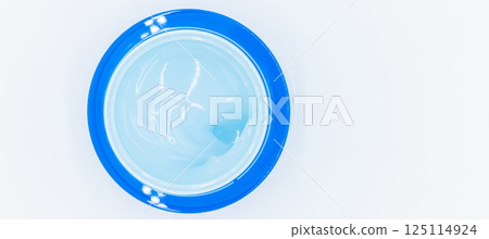 Top view blue water gel cosmetic serum in blue container, Liquid gel moisturizer, Blue gel serum texture make up and cosmetic texture background, skincare product and beauty cream. 125114924