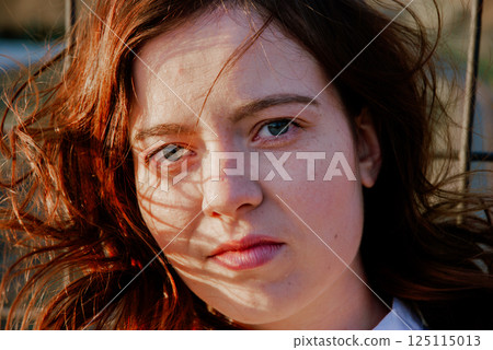 Portrait of a woman with wind-swept hair outdoors 125115013