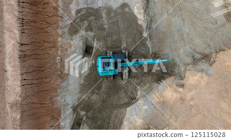 Excavator digs move earth at construction site, Excavator working and digging at construction site, Crawler excavator digger earth gravel on transportation truck at construction site, Top view 125115028