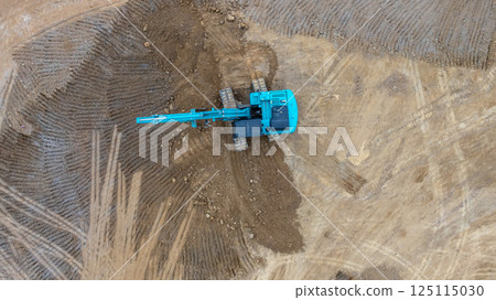 Excavator digs move earth at construction site, Excavator working and digging at construction site, Crawler excavator digger earth gravel on transportation truck at construction site, Top view 125115030