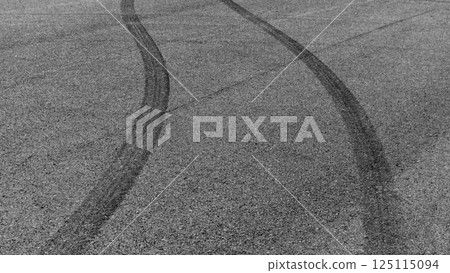 Car tire mark burnout on asphalt road race track, Abstract car tire mark from car on the asphalt road, Tire mark on race track texture and background, Black tire track skid mark on asphalt road. 125115094