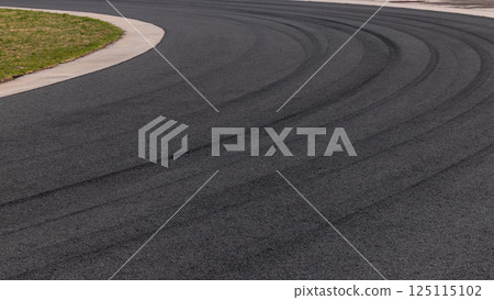 Tire mark on curve race track, Abstract black tire mark on race track, Abstract background black tire mark skid on asphalt road racing circuit, Tire track on curve road race speed track circuit. 125115102