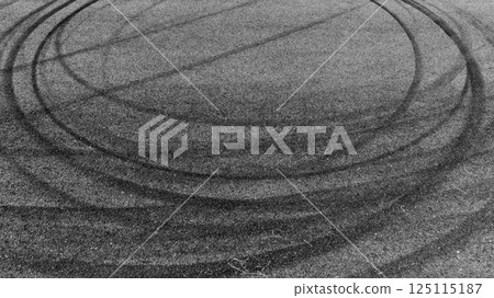 Black car tire marks on asphalt car race track circuit, Car tire mark on speed track texture and background, Abstract car tire mark on race track, Top view car tire track. Black car tire marks on asphalt car race track circuit, Car tire mark on speed track texture and background, Abstract car tire mark on race track, Top view car tire track. 125115187