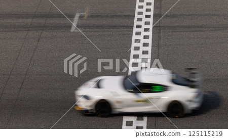 Motion blurred super car crossing finish line checkered on race track circuit, Race super car blurred motion crossing finish checkered line on race track, concept win and goal reached. 125115219