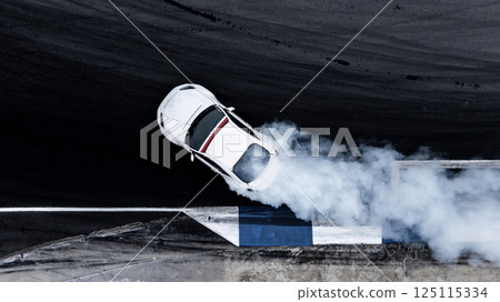Motorsport car drift on asphalt race track with lot of smoke from burning wheel tires rubber, Drift motorsport car drift race, Professional driver drift car on asphalt race track, Car motion blurred. 125115334
