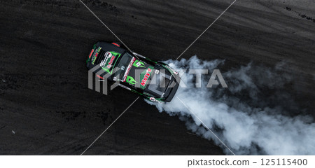 Car drift on asphalt race track with lot of smoke from burning wheel tires rubber, Drift motorsport car drift race, Professional driver drift car on asphalt race track, Car motion blurred motorsport. Car drift on asphalt race track with lot of smoke from burning wheel tires rubber, Drift motorsport car drift race, Professional driver drift car on asphalt race track, Car motion blurred motorsport. 125115400
