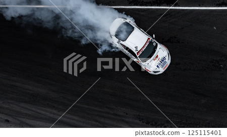 Car drift on asphalt race track with lot of smoke from burning wheel tires rubber, Drift motorsport car drift race, Professional driver drift car on asphalt race track, Car motion blurred motorsport. 125115401