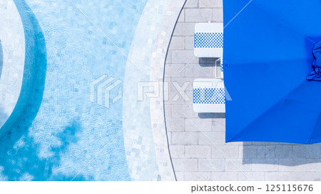 Top view swimming pool blue water in summer with umbrella pool and deck beach chair, Empty swimming pool with sunbed and umbrella pool in resort hotel for vacation leisure, Summer vacation holiday Top view swimming pool blue water in summer with umbrella pool and deck beach chair, Empty swimming pool with sunbed and umbrella pool in resort hotel for vacation leisure, Summer vacation holiday 125115676