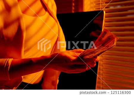 Businesswoman Counting Euro and Dollar Bills by Window. 125116300