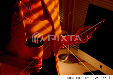 Businesswoman Holding Coffee Cup and Checking Phone. Businesswoman Holding Coffee Cup and Checking Phone. 125116301