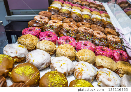 Colorful Assorted Donuts Displayed in Bakery Shop Showcase 125116563