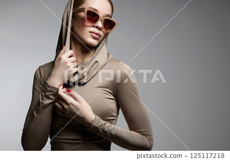 fashion portrait of Beautiful young woman in sunglasses and hood 125117218