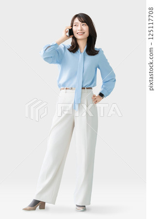 Smiling woman/businesswoman talking on smartphone 125117708