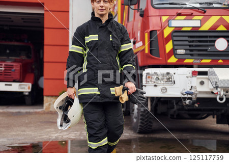 Walking forward. Woman firefighter in uniform is at work in department 125117759