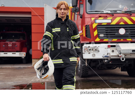 Walking forward. Woman firefighter in uniform is at work in department 125117760
