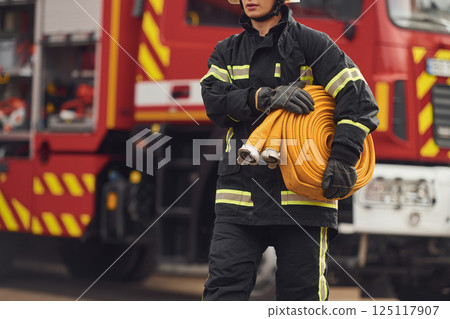Holding fire hose. Woman in uniform is at work in department Holding fire hose. Woman in uniform is at work in department 125117907