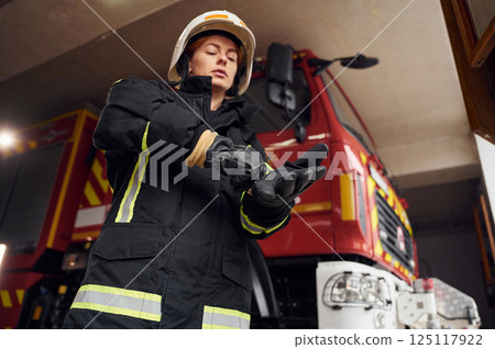 Wearing protective equipment. Woman firefighter in uniform is at work in department Wearing protective equipment. Woman firefighter in uniform is at work in department 125117922