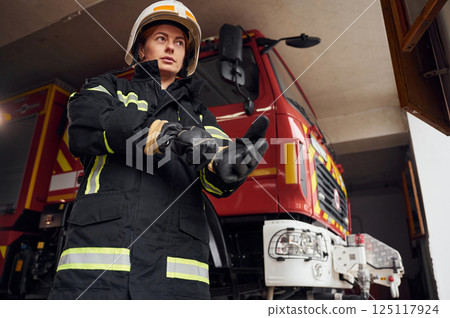 Wearing protective equipment. Woman firefighter in uniform is at work in department Wearing protective equipment. Woman firefighter in uniform is at work in department 125117924
