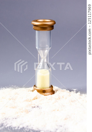 Vertical image. Hour glass with sand pouring out. Illustration that we do not have as much time as we think. Do not waste your time concept. 125117969