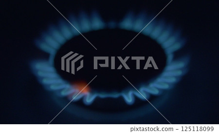 A close view of a vivid blue gas flame on a stove, showcasing its vibrant color and heat 125118099