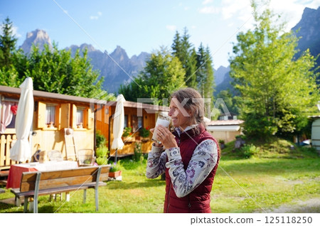 Woman Enjoying Coffee in Scenic Mountain Campground 125118250