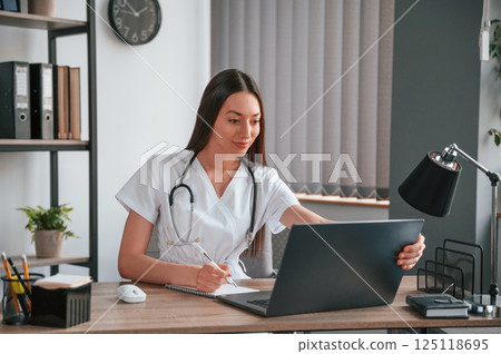 Doing online consultation. Young beautiful female doctor in white coat is in the office 125118695