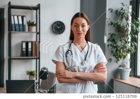 Portrait of young beautiful female doctor in white coat that is in the office 125118709
