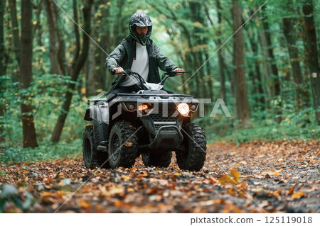 ATV driver is in the forest, having a ride at daytime 125119018