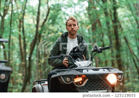 With safety helmet. TV driver is in the forest, having a ride at daytime 125119055