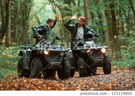 Two male atv riders is in the forest together Two male atv riders is in the forest together 125119069