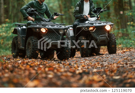 Two male atv riders is in the forest together Two male atv riders is in the forest together 125119070