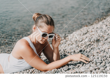 Freelance close up woman hands writing on computer. Well looking middle aged woman typing on laptop keyboard outdoors with beautiful sea view. 125119150