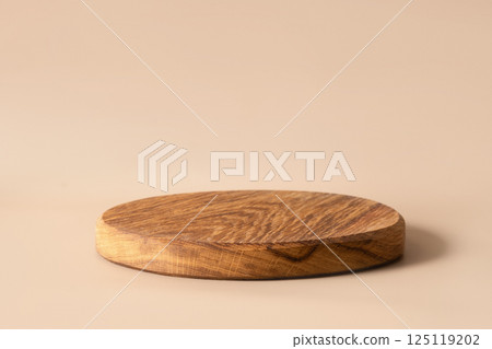 Wooden empty cutting board on beige background. Space for design. Cooking concept with copy space. 125119202