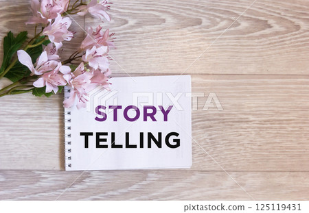 The text of the Storytelling written in a notebook on a wooden background 125119431