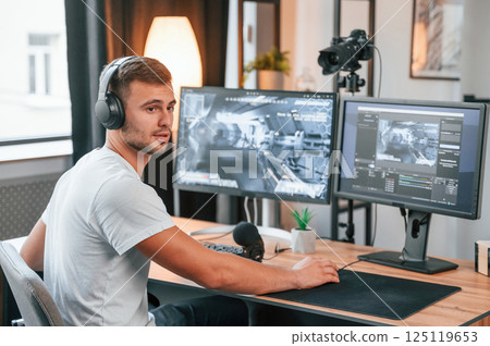 Process of recording. Young man playing and streaming the first person shooter game 125119653