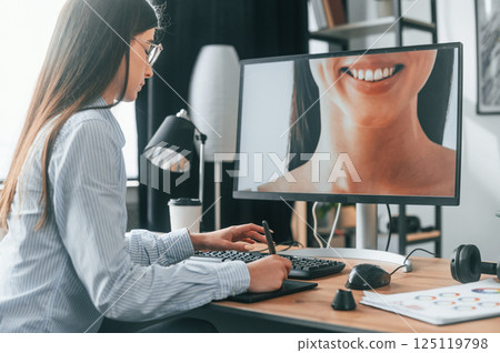 Portrait of woman. Young female retoucher working with computer and graphic tablet Portrait of woman. Young female retoucher working with computer and graphic tablet 125119798