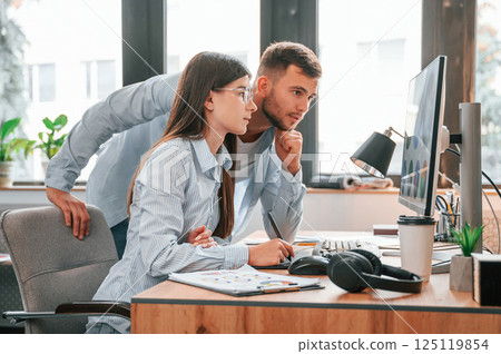 Using computer. Two young designers is working together in the office 125119854