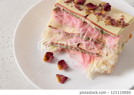 Trendy white, pink chocolate with layer of white and pink pismaniye on white background. Tasty dessert with Cotton candy. Luxury dessert. Close up. 125119880