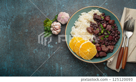 Feijoada, traditional brazilian stew with black beans, rice, and orange slices, top view 125120093