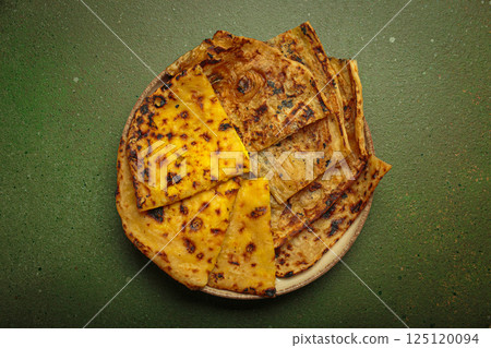 Delicious Indian naan flatbreads served on a plate on green background top view 125120094