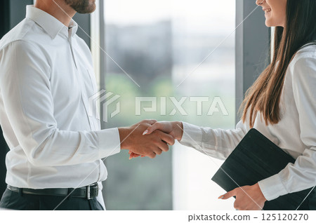 With tablet in hands. Man and woman in formal clothes are working together indoors 125120270