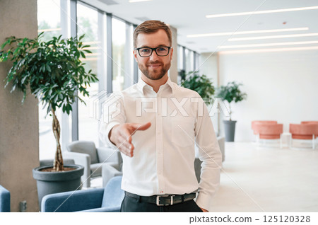 Giving hand to make handshake. Elegant man in formal clothes is indoors Giving hand to make handshake. Elegant man in formal clothes is indoors 125120328