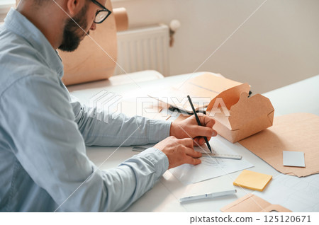Drawing process. Print house worker in white clothes is indoors Drawing process. Print house worker in white clothes is indoors 125120671