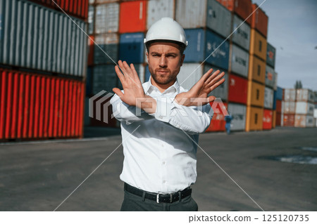 No trespassing. Area is closed. Male worker is on the location with containers 125120735