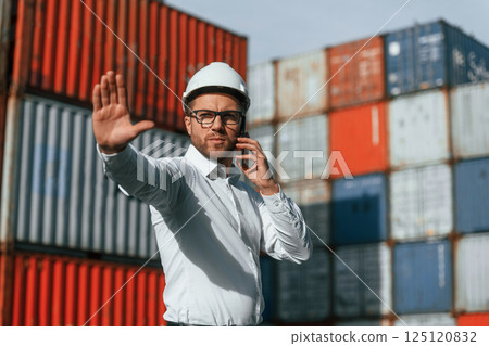 Restricted area. No trespassing. Male worker is on the location with containers 125120832