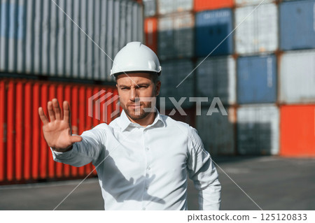 Restricted area. No trespassing. Male worker is on the location with containers Restricted area. No trespassing. Male worker is on the location with containers 125120833