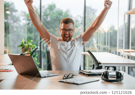 Uplifting mood. Man in formal clothes is working in the modern office 125121026