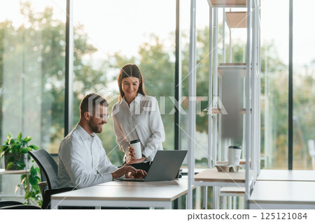 Sharing ideas. Man and woman are working in the modern office together Sharing ideas. Man and woman are working in the modern office together 125121084