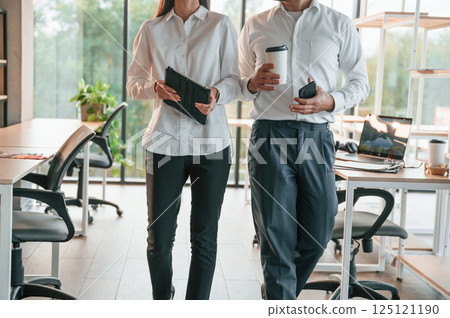 Front view. Man and woman are working in the modern office together Front view. Man and woman are working in the modern office together 125121190