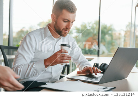 Using laptop. Man and woman are working in the modern office together 125121214
